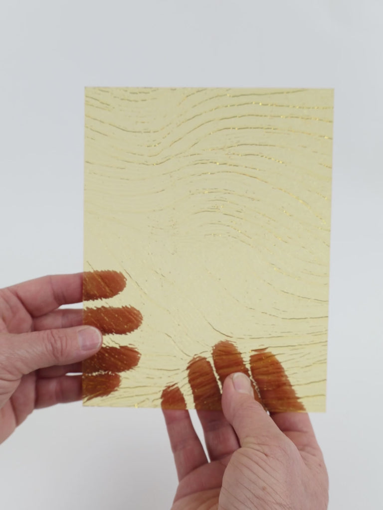 Video of the pale amber ripple glass plate in yellow transparent, 15x19cm, held up and tilted to show its pattern and transparency