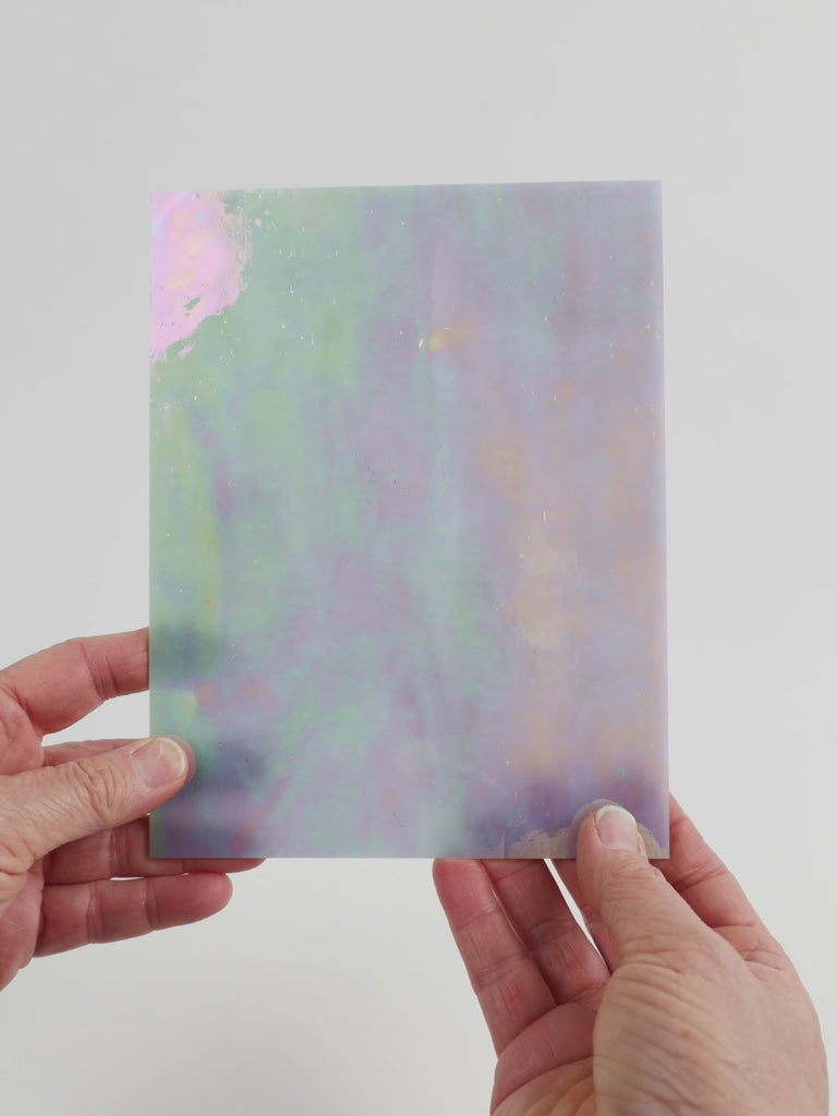 Video of the silver star opal glass plate in silver iridescent translucent, 15x19cm, held up and tilted to show its pattern and transparency
