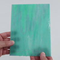 Video of the Pale Teal Iridised glass plate in iridised translucent teal, 15x19cm, held up and tilted to show its pattern and transparency