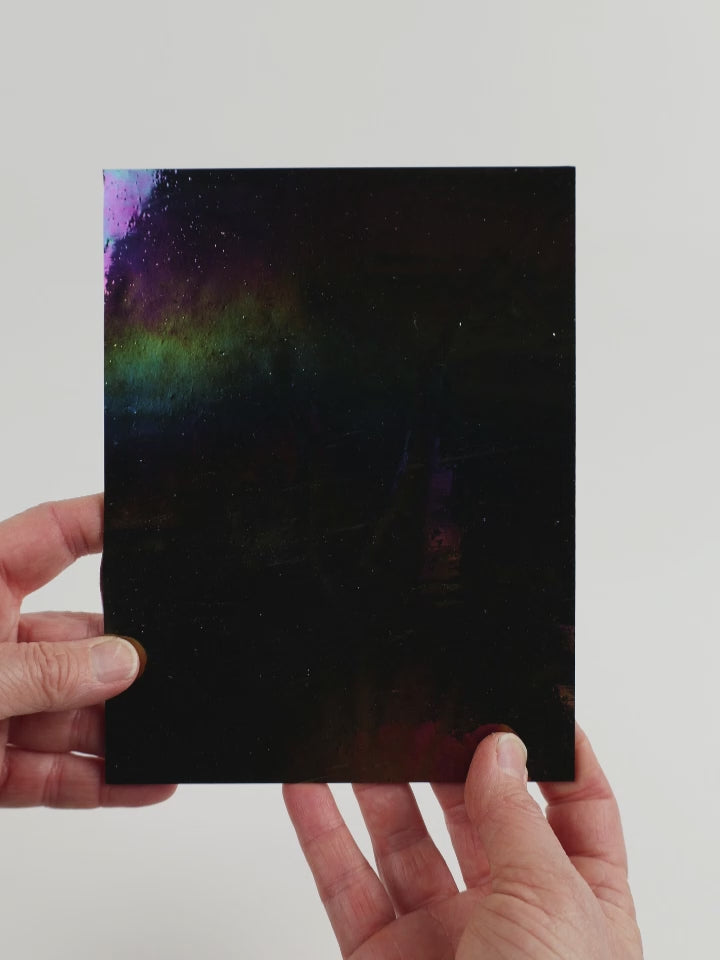 Video of the Universe glass plate in black, opaque and iridescent finish, 15x19cm, held up and tilted to show its pattern and transparency